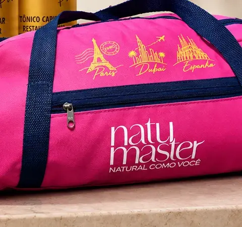 Bolsa de viagem rosa da Natumaster com alças azul-marinho sobre bancada de mármore
